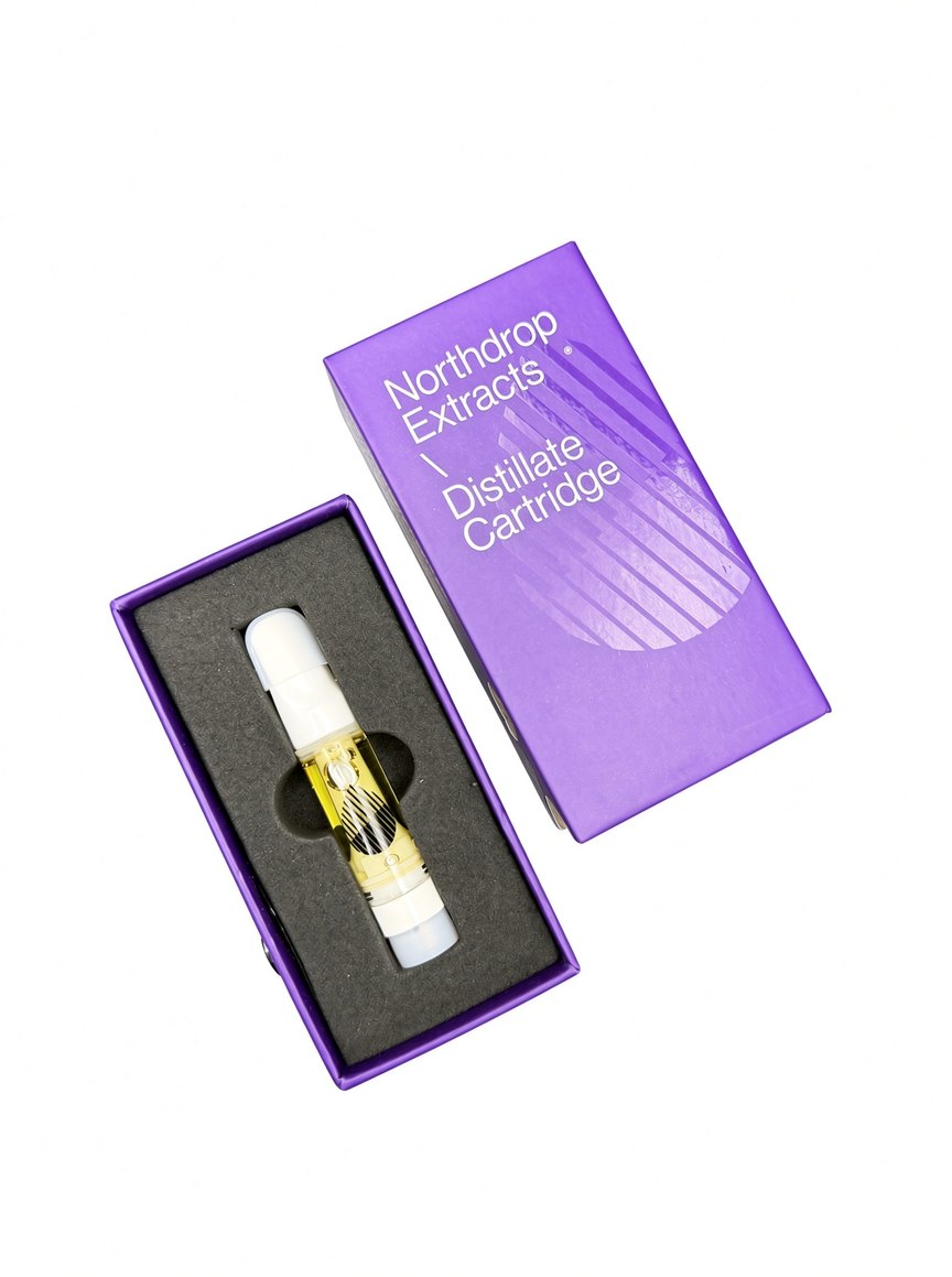 Distillate cartridge resting in the foam tray beside the closed purple box