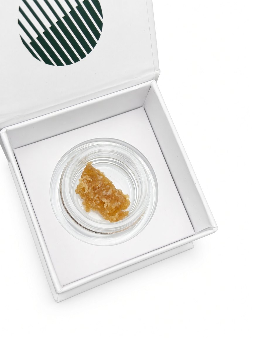 Resin in its glass jar seated inside the opened white box, shot on white